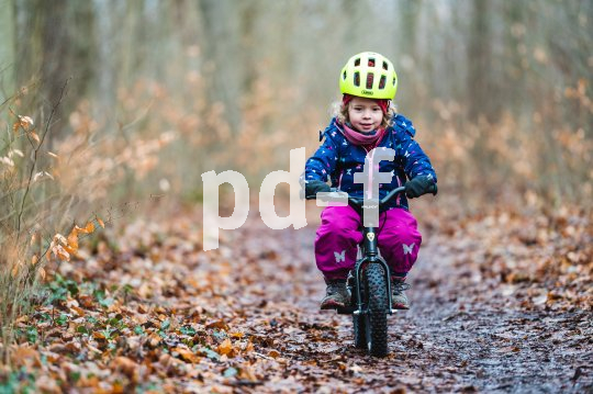 Kind mit Laufrad im Wald