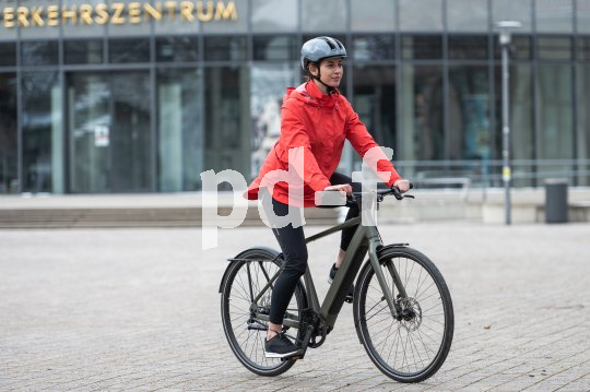 Frau fährt auf E-Bike in Stadt