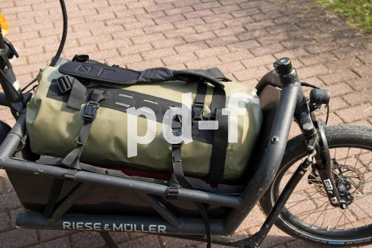 Eine Sport- und Reistasche auf der Ladefläche eines Cargobikes.