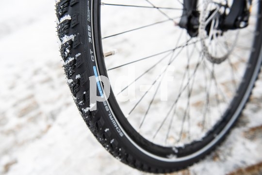 Schnee im Profil eines Fahrradreifens für den Einsatz im Winter.