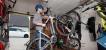 Ein Mann platziert ein E-Bike in einer Garage an einer speziellen Wandaufhängung für Fahrräder.