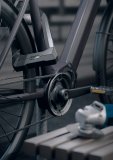 Ein Fahrrad ist mit dem Bügelschloss Granit Super Extreme 2500 von ABUS an einem Fahrradständer angeschlossen. Im Vordergrund liegt ein Trennschleifer  auf einer Bank.