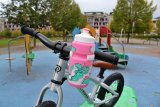Eine rosa Trinkflasche am Lenker eines Kinderfahrrads montiert.