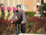 Ein Mann fährt auf einem Fahrrad durch ein Wohngebiet.