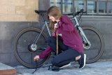 Frau pumpt Fahrradreifen auf