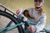 Frau schließt Fahrrad an Anlehnparker