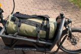 Eine Sport- und Reistasche auf der Ladefläche eines Cargobikes.